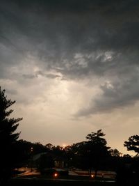 View of illuminated street lights against cloudy sky