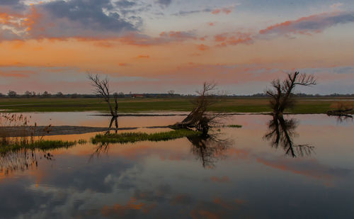 Scenic view of lake against sky at sunset