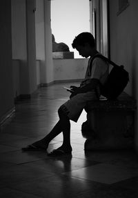 Side view of young woman using mobile phone