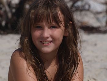 Close-up portrait of smiling teenage girl at beach