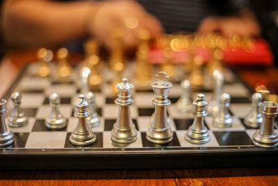 Close-up of silver chess pieces on board