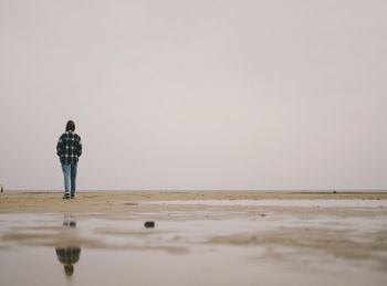 Rear view of man standing on beach