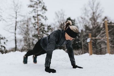 Woman doing push-ups at winter