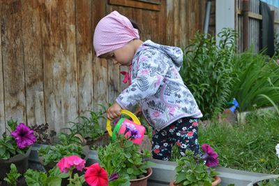 A child waters flowers from a watering can