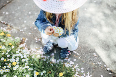 Low section of woman holding white flowering plants