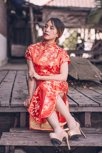 Woman looking away while sitting outdoors