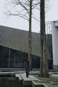 Rear view of woman walking by building