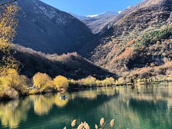 Scenic view of lake by mountains against sky