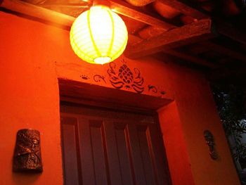 Low angle view of illuminated lighting equipment hanging on ceiling