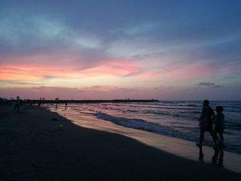 Silhouette people walking on beach