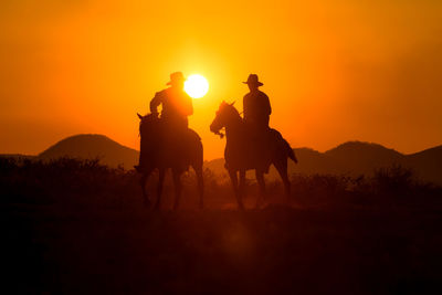 Silhouette man riding horse against sky during sunset