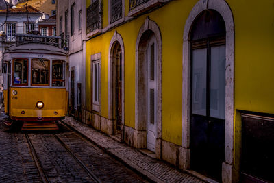 View of yellow tram amidst buildings in city