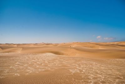 Scenic view of desert against clear blue sky