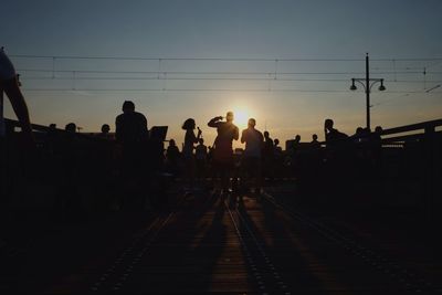 Railroad tracks against sky at sunset