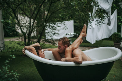 High angle view of shirtless man in bathtub