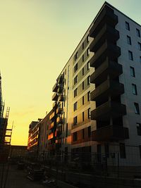 Low angle view of buildings against sky at sunset