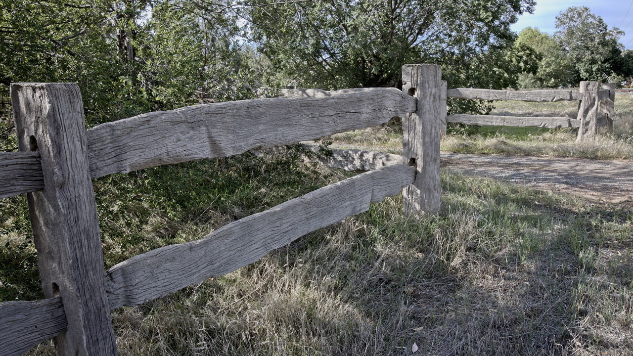 WOODEN FENCE IN FIELD