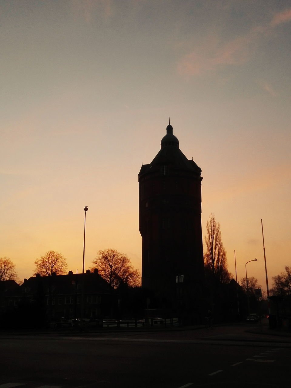 sunset, silhouette, architecture, built structure, building exterior, orange color, clear sky, sky, low angle view, copy space, street light, dusk, outdoors, tree, no people, road, sun, tower, sunlight, nature