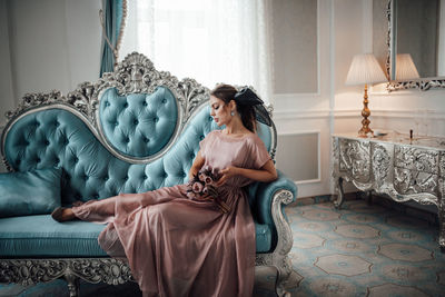 Woman sitting on sofa at home