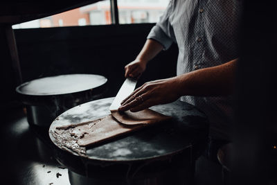 Hands of male chef preparing pancakes in restaurant kitchen