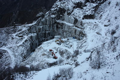 Quarries of carrara marble excavation site in mountains of apuan alps in white snow of winter