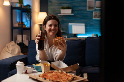 Portrait of young woman having food at restaurant