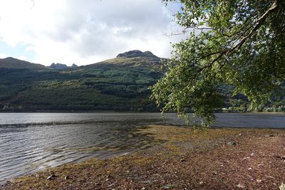 Scenic view of lake by mountains against sky