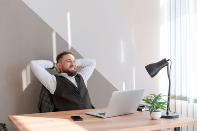 Portrait smiling man with beard, working in office on some project, he sits