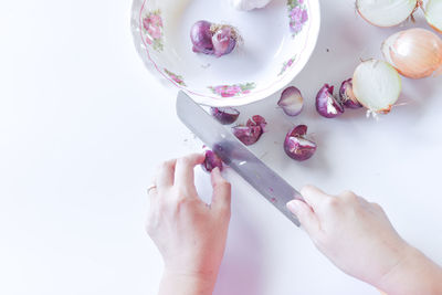 Close-up of hand holding ice cream over white background