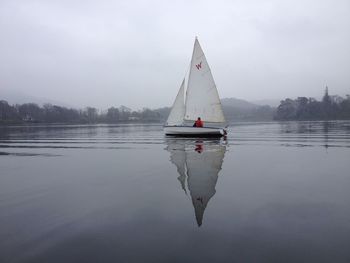 Sailboat in lake against sky