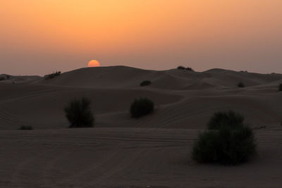 Scenic view of desert against orange sky