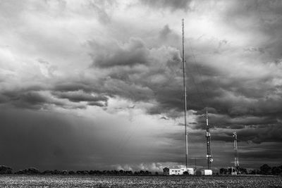 Low angle view of electricity pylon on field against sky