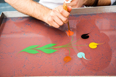 Midsection of person holding paper painting