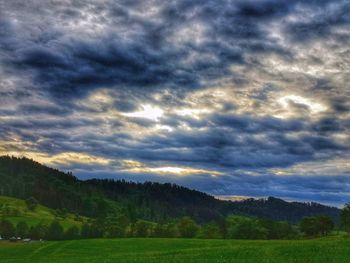 Scenic view of field against cloudy sky