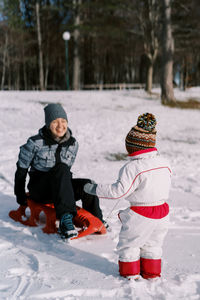 Full length of boy standing on snow covered field