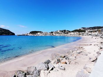 Scenic view of beach against clear blue sky