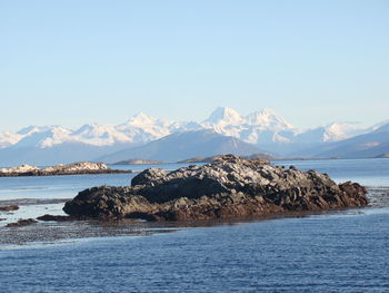 Scenic view of sea and mountains against sky