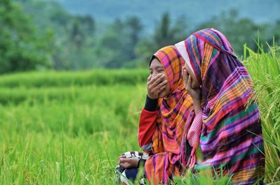 Close-up of smiling woman sitting in grass