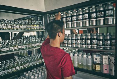 Portrait of man standing in front of bottles