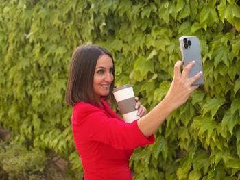 Mature woman taking a selfie while drinking coffee