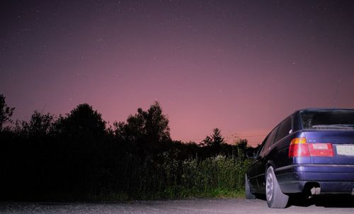 Road amidst trees against clear sky at night