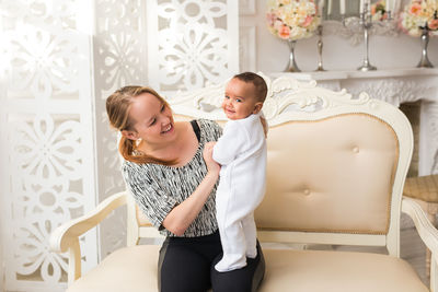 Side view of mother and daughter sitting at home