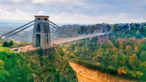 Bridge over mountain against cloudy sky