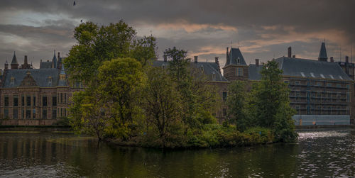 Buildings by river against sky at night