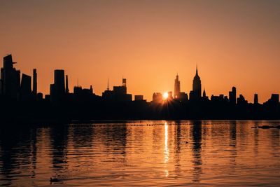 Silhouette of buildings in city during sunset for new york 