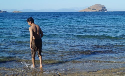 Man standing on sea shore against sky