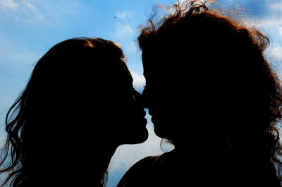 Close-up of silhouette woman with reflection against sky