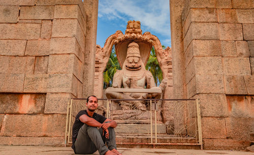 Rear view of man against statue in temple