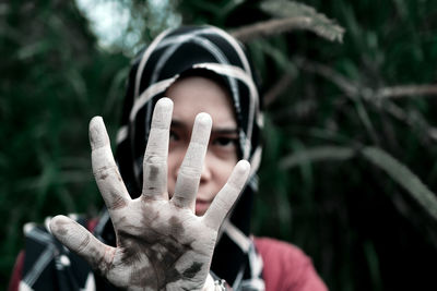 Close-up of woman gesturing stop sign with dirty hand