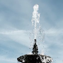 Water splashing on fountain against sky